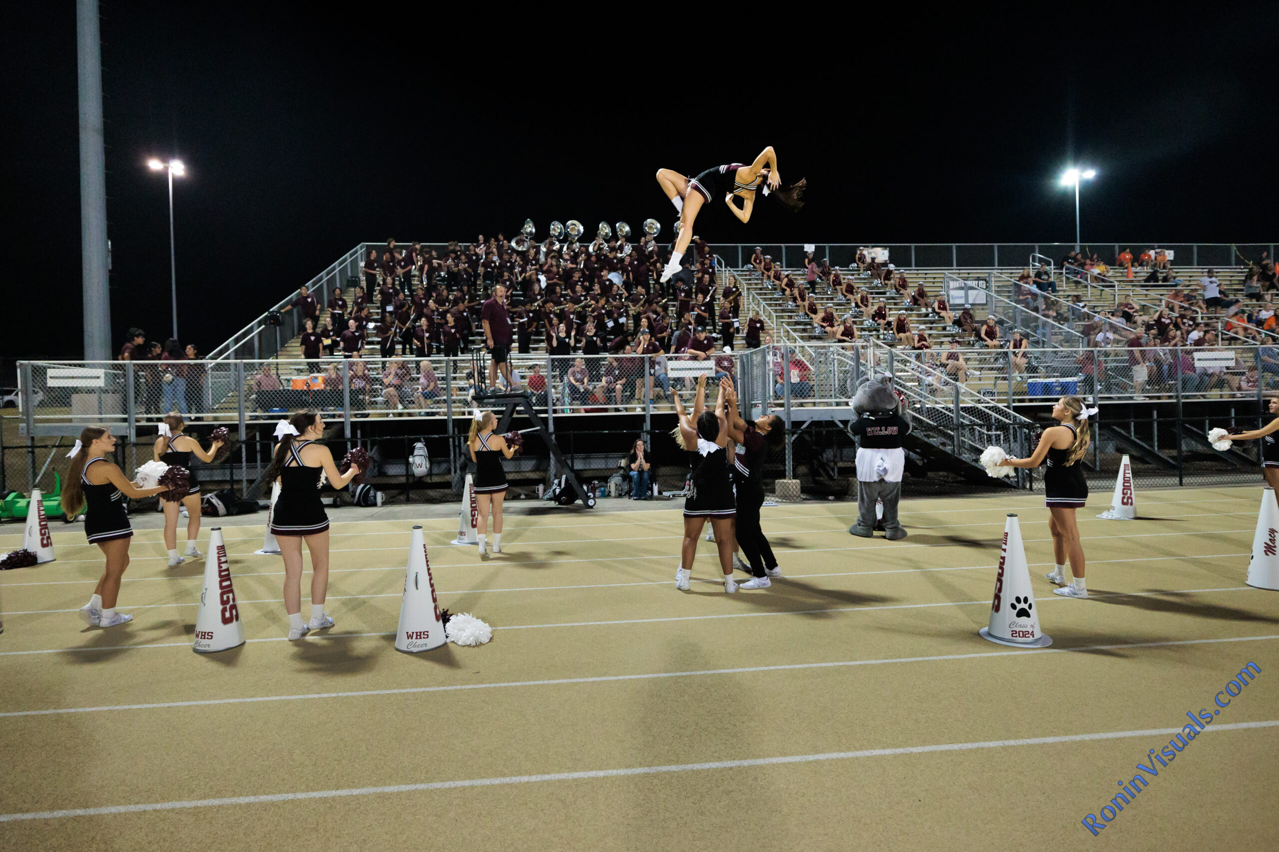 2023 Waller cheer captain Natalie Barish (midair) performs her "pretty girl" basket toss during the third game of a football season, Friday, Sept. 8, 2023. (Photo courtesy RoninVisuals.com)