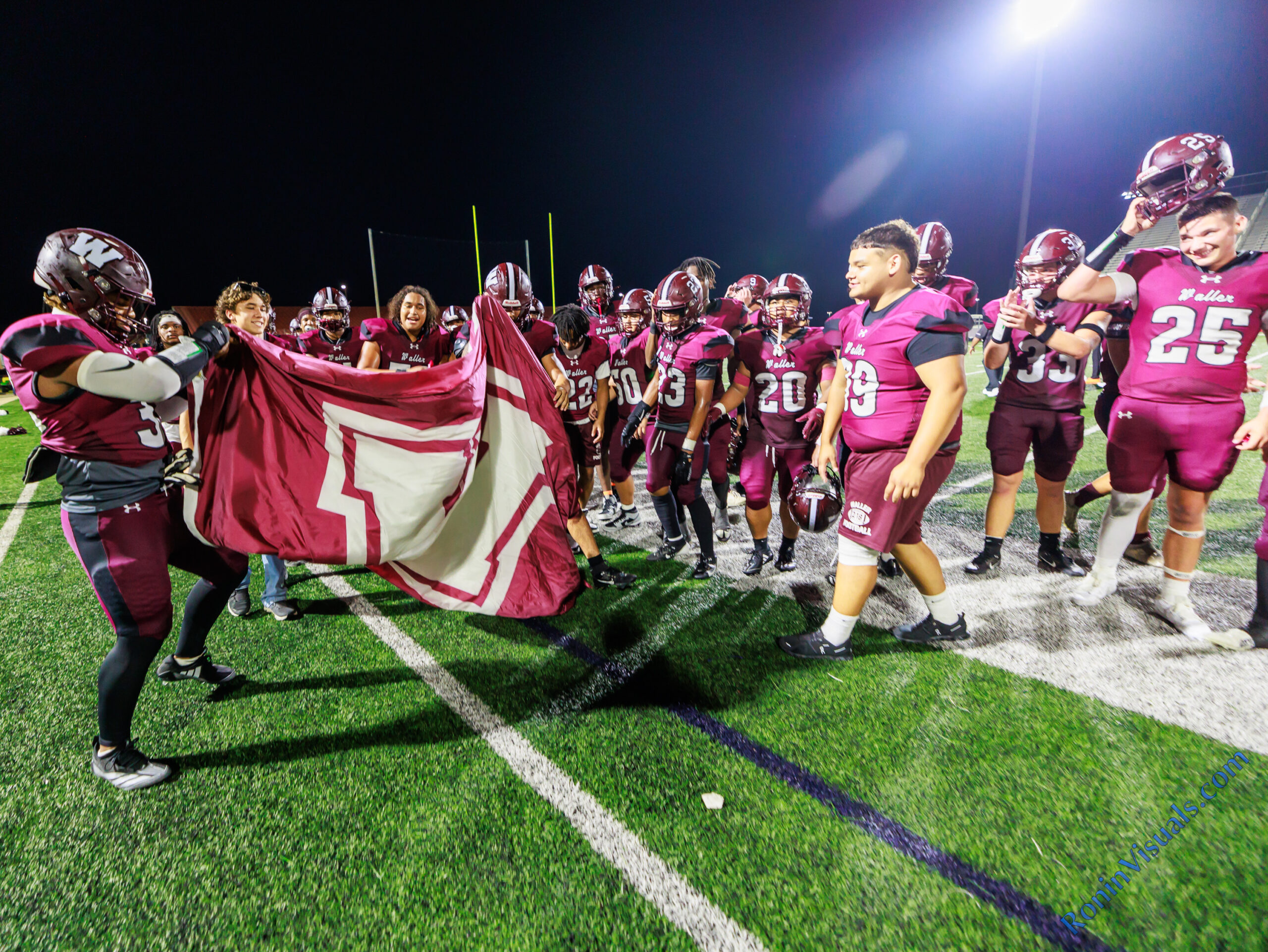 The Waller Bulldog football team unveils the victory flag after defeating Conroe Caney Creek, 41-7, for the Bulldog’s first victory at home since 2021, at Daikin Stadium, Aug. 31, 2024. (Photo by Creighton Holub, courtesy RoninVisuals.com)